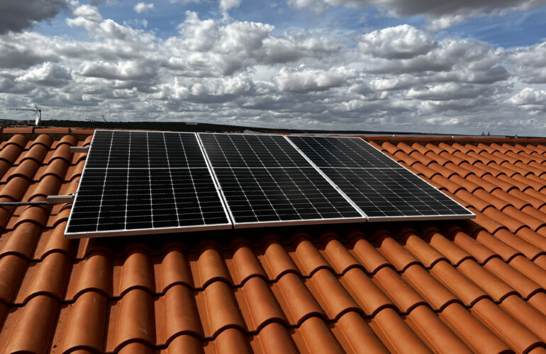 Paneles solares en tejado con cielo nublado