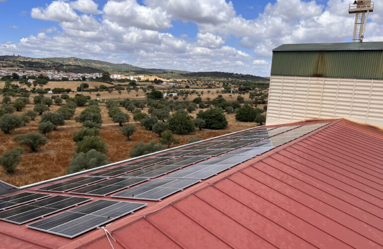 Paneles solares en techo con paisaje rural.