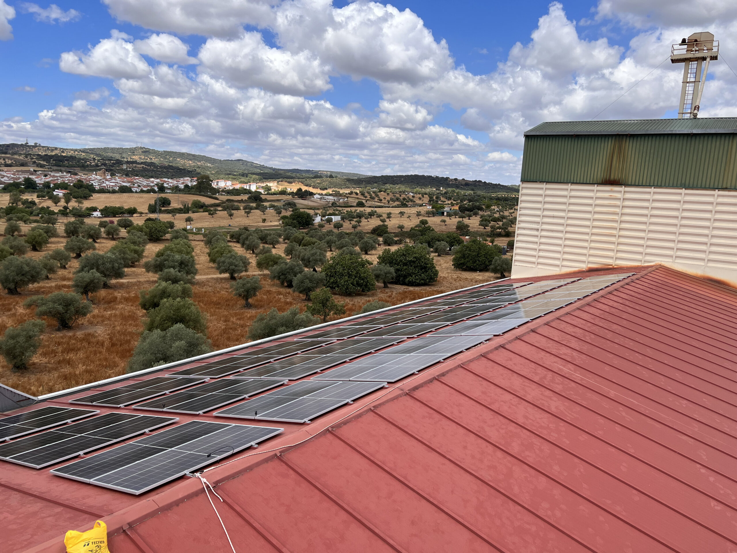 Paneles solares en techo con paisaje rural.